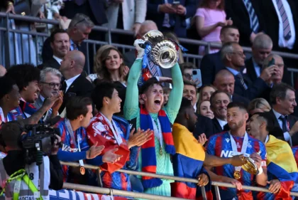 Ada haru yang menyelimuti perayaan juara Piala FA Crystal Palace. Kiper heroik mereka, Dean Henderson, tak kuasa menahan air mata saat mempersembahkan trofi bersejarah itu untuk mendiang ayahnya. (cr/cpfc)