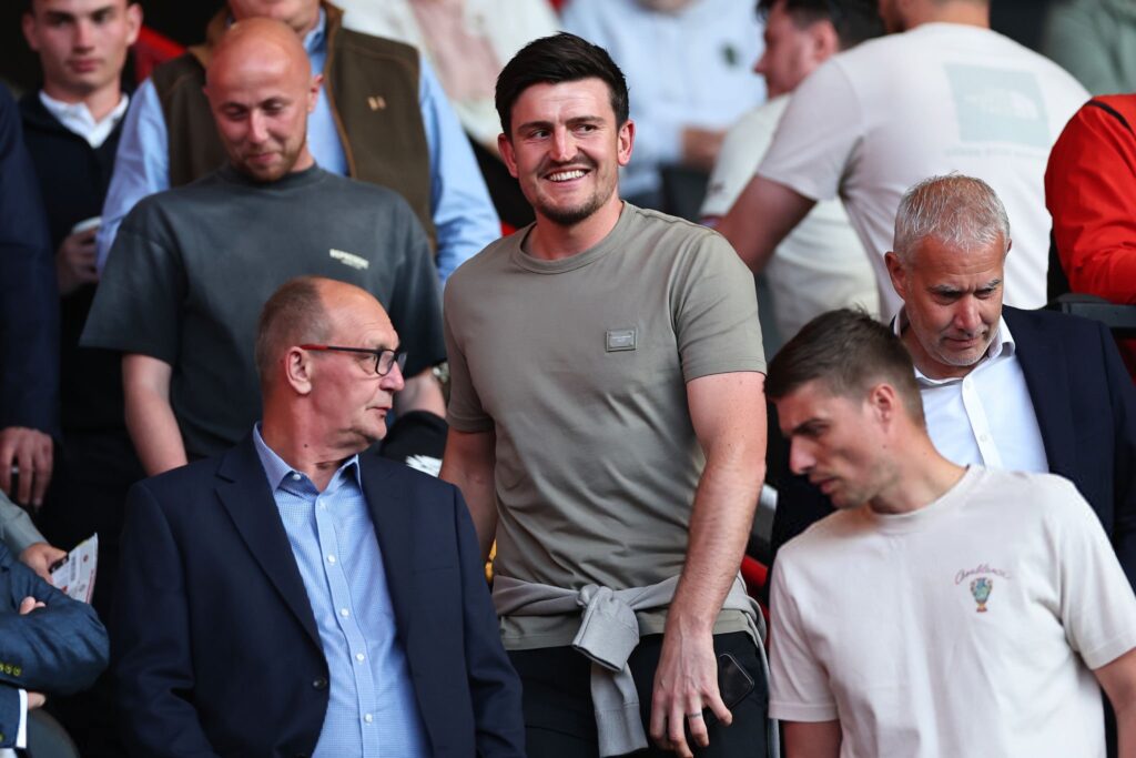 Bek tengah Manchester United, Harry Maguire, tampak mencari pelarian sejenak dari tekanan dan performa kurang memuaskan timnya dengan menyaksikan langsung keberhasilan mantan klubnya, Sheffield United, melaju ke final play-off Championship. (cr/x.com)